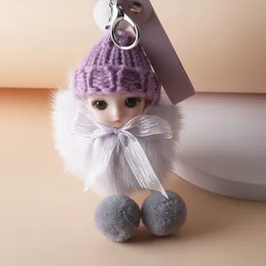Detail view of a cute plush doll keychain featuring a purple knit hat and silver bow
