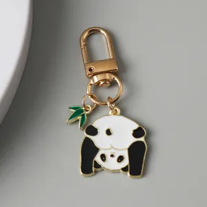 Close-up of cute enamel panda keychain with gold-plated hook and bamboo leaf detail