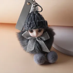 Close-up of a cute plush doll keychain with grey knit hat and silver bow details
