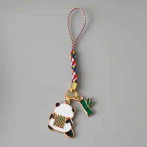 Close-up detail of a cute panda and green bamboo charm with a vibrant rainbow braided cord