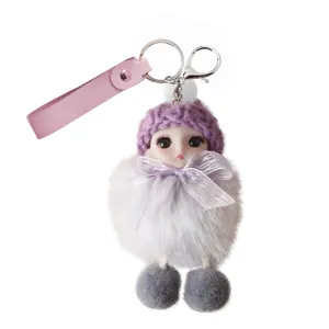 Close-up of a cute plush doll keychain with purple knit hat and white fur pom-pom