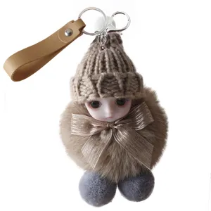 Detailed close-up of a cute plush doll keychain featuring a knitted hat and satin bow
