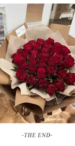 Grosse rote Rosenblumenstrauss verpackt in Kraftpapier elegante Blumen Geschenke Frische