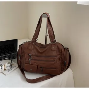 Detail view of the vintage washed leather motorcycle shoulder bag with multiple zippers.