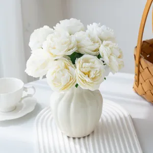 Bouquet de fleurs de pivoine artificielle blanche en vase en ceramique pour salon.