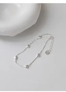 Primer plano detalle de la pulsera de plata esterlina con colgantes de corazones mujer.