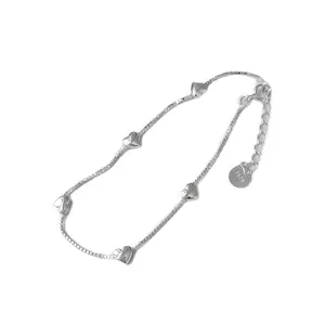 Primer plano de la pulsera de plata con corazones, detalle fino de los eslabones.