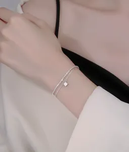 Delicate double layer sterling silver bracelet featuring a sparkling square crystal pendant.
