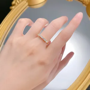 Primo piano dettagliato di un anello in oro scintillante con zirconi indossato sulla mano.