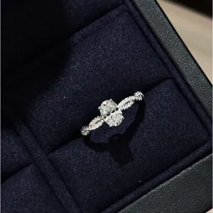 Primer plano detallado del anillo ovalado retorcido de plata S925 con circonitas brillantes.