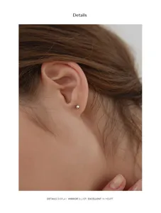 Close-up detail of minimalist S999 pure silver ball ear stud worn on ear cartilage.