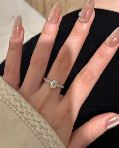 Primer plano detallado de un anillo ovalado de plata de ley con pavé trenzado en la mano.