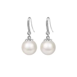 Detalle de pendientes colgantes de perlas blancas, diseño minimalista de plata para mujeres.