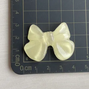 Grande fiocco in resina trasparente glitterata dettaglio, accessorio DIY effetto ghiaccio.