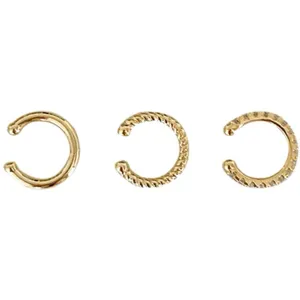 Nahaufnahme von drei goldenen Ohrklammern ohne Piercing mit glatten und funkelnden Steinen.
