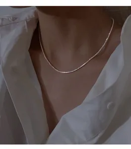 Detailed shot of a shimmering silver collarbone chain necklace, delicate sparkling texture.