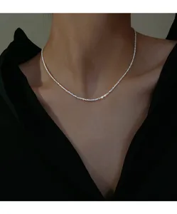 Detailed shot of sparkling sterling silver collarbone chain worn on neck, minimalist design.