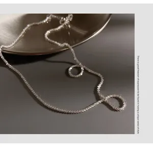 Detail shot of sparkly silver sparkle chain necklace, delicate shimmering texture, close-up view.