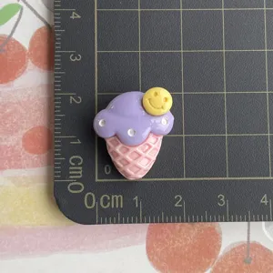 Close-up detail of cute purple ice cream resin cabochon with smiley face for DIY phone case.
