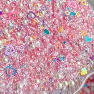 Close-up detail of mixed DIY craft beads, pearls, rhinestones, and heart charms for slime.