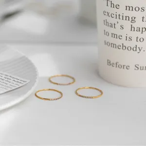 Primer plano de detalle del anillo de plata minimalista con finas piedras brillantes.