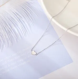 Silver heart pendant detail shot, minimalist delicate chain jewelry design showcase closeup.