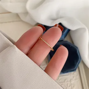 Primer plano de un anillo fino de plata con pavé de circonitas brillantes llevado en la mano.