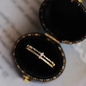 Primer plano detallado de un anillo doble de plata esterlina con piedras brillantes.