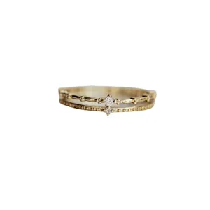 Primer plano detallado de un elegante anillo doble de plata esterlina con piedras brillantes.