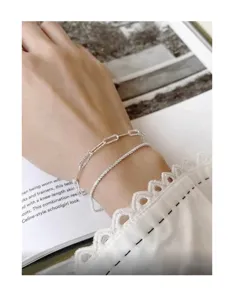 Primer plano detallado de pulseras de plata esterlina en capas con elegante estilo.