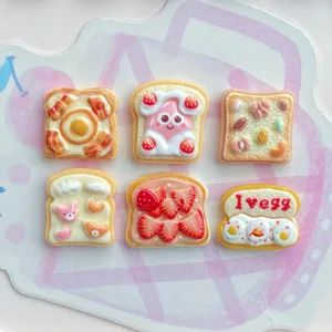 Detail view of cute strawberry egg toast resin charms for DIY crafts and accessories.