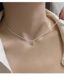 Close-up detail of the sparkling sterling silver chain with olive green cubic zirconia pendant.