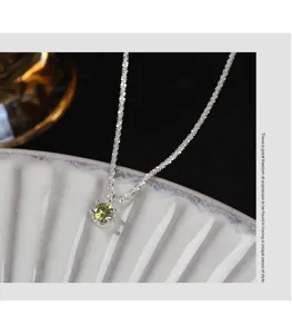Detailed close-up of the sterling silver necklace featuring an olive green zircon pendant.