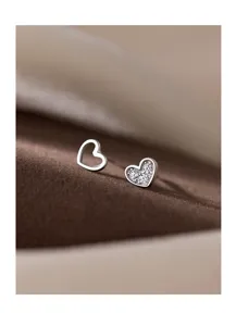 Nahaufnahme minimalistischer s925 Silber asymmetrischer Herz Ohrstecker, zart.