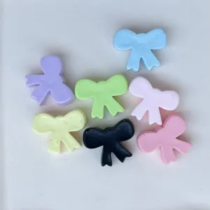 Mini resin bow charms close up for DIY nail art jewelry crafts and hair clips making.