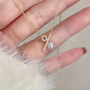 Detalle en primer plano del collar de perlas con símbolo de porcentaje de plata s925, elegante.