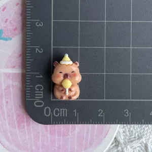 Mini resin capybara charm detail shot showing size on grid mat, perfect for DIY phone case decor.