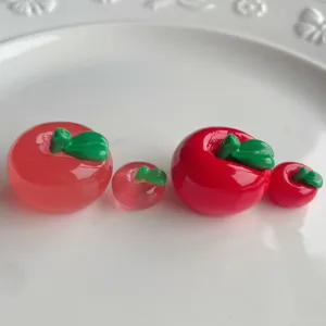 Primo piano dettagliato di ciondoli in resina a forma di mela per accessori fai da te.
