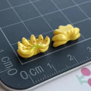 Vista in primo piano di ciondoli a banana in resina in miniatura, perfetti per cover e decorazioni.