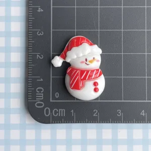 Resin Christmas snowman cabochon charm detail view with red hat and scarf decoration.