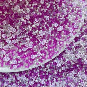 Detail shot of mixed purple and white soft clay cat claw beads and bubble beads for DIY crafts.