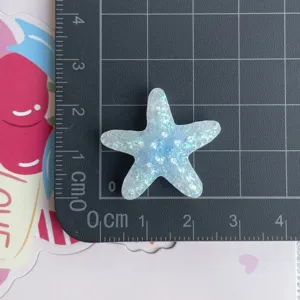 Vue de détail de breloque en résine étoile de mer pailletée pour accessoires artisanaux faits main.