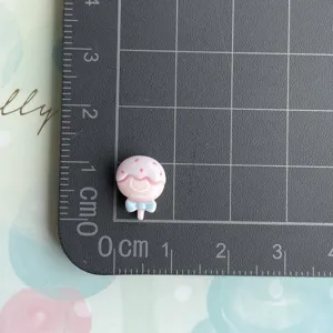 Mini cute pink cartoon resin cabochon DIY charm detail view showing size on grid mat