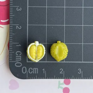 Dettaglio ciondolo frutta durian in resina in miniatura su righello griglia per fai da te.