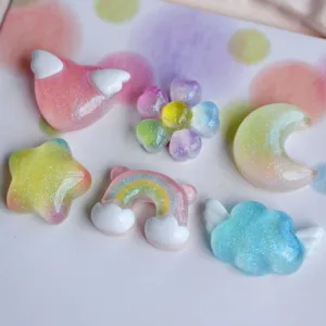 Dettaglio ciondoli in resina con sfumature colorate e glitter per decorazioni fai da te.