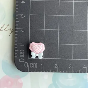 Pink heart resin cabochon with bow detail, perfect for DIY crafts and accessories.