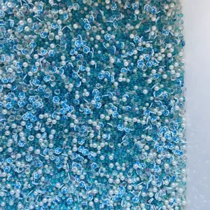 Closeup of mixed blue cat paw clay slices and sparkling crystal beads for DIY crafts.