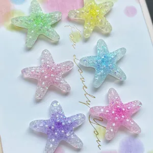 Gros plan détaillé de charmants pendentifs étoile de mer en résine scintillante et colorée.