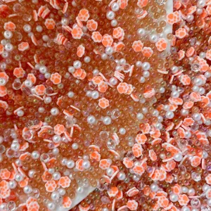 Colorful polymer clay cat paw beads mixed with pearls and crystals for DIY slime and crafts.
