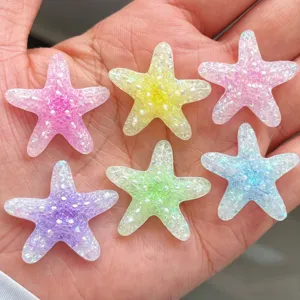 Gros plan détaillé de charms d'étoiles de mer en résine pailletée, parfaits pour les loisirs créatifs.